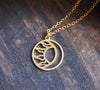 Round, matte gold moon and sun circle necklace on wood background