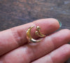 Gold crescent moon and mushroom ring held in hand