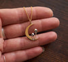 Crescent moon and mushroom necklace shown in hand