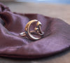 Crescent moon and mushroom ring displayed on purple taffeta bag