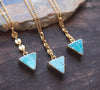 Angled picture of 3 gold edged, triangle gemstone necklaces with coin detail