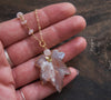 Pink agate leaf necklace in hand
