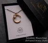 Matte gold plated crescent moon necklace on dark brass chain with delicate rainbow moonstone accent displayed gift box