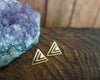Shiny gold geometric triangle stud earrings side view with amethyst stone in the background