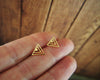 Shiny gold geometric triangle stud earrings shown in hand for scale